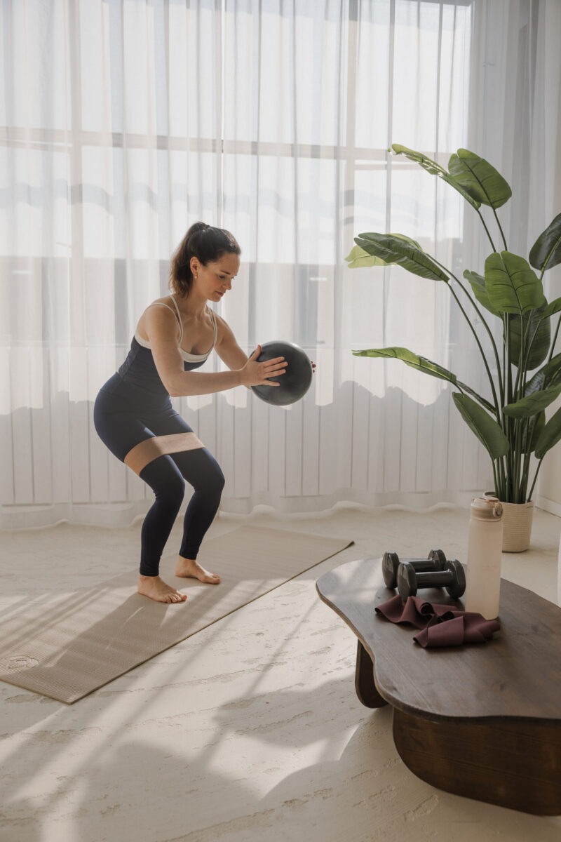 Het doen van pilates oefeningen bij een zakelijke fotoshoot in daglichtstudio in Eindhoven voor Roots Pilates Portfolio voor social media door Frame your content zakelijke fotograaf en videograaf
